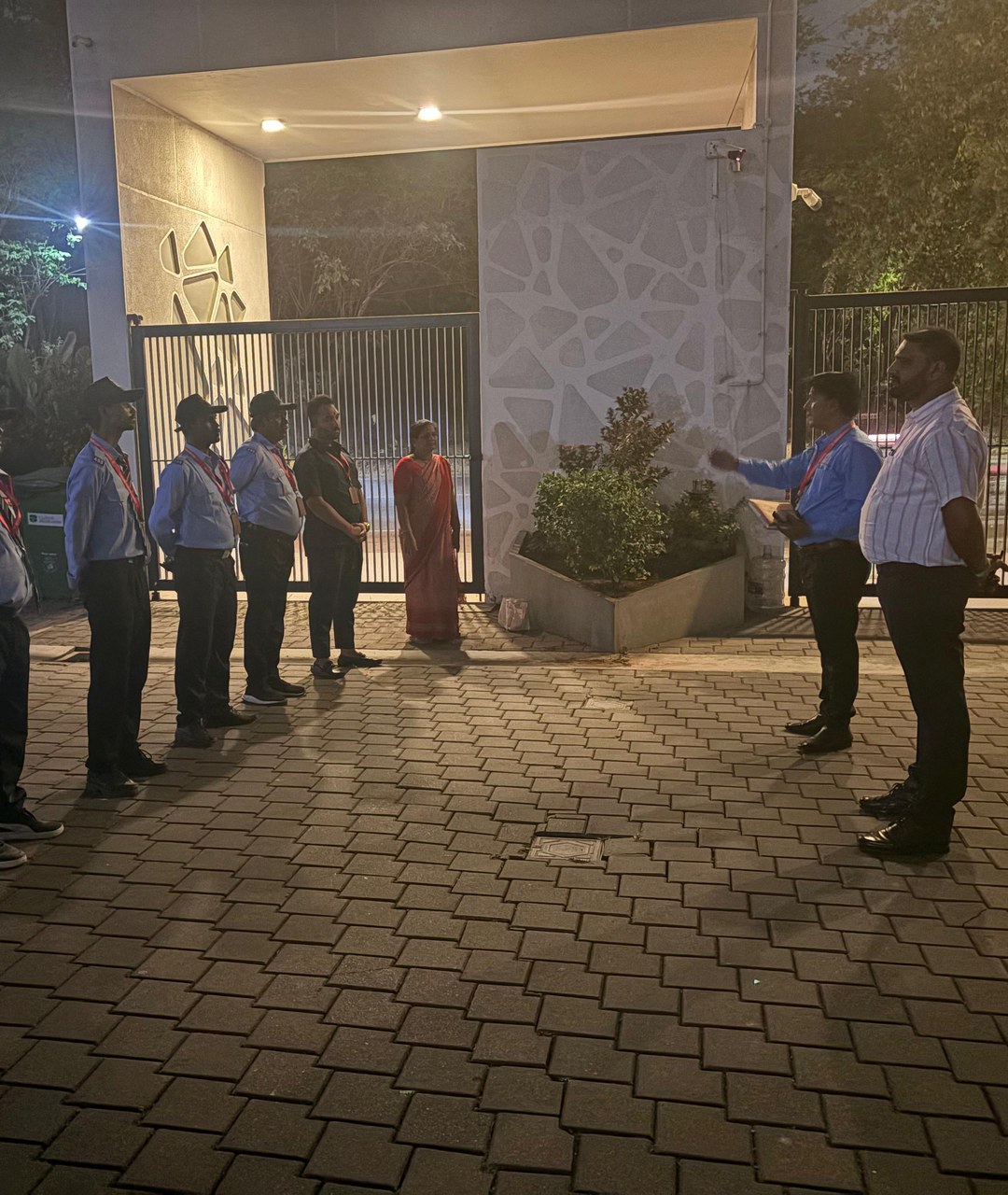 Assured Security Services team during a night briefing at a client entrance