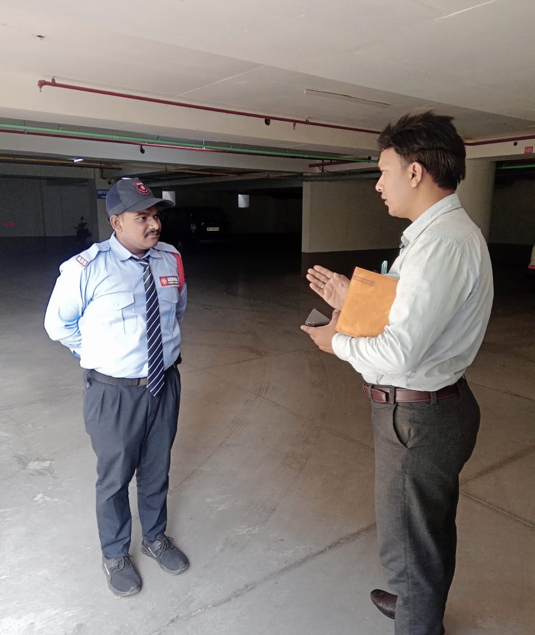 Assured Security Services supervisor speaking with a guard during a site inspection
